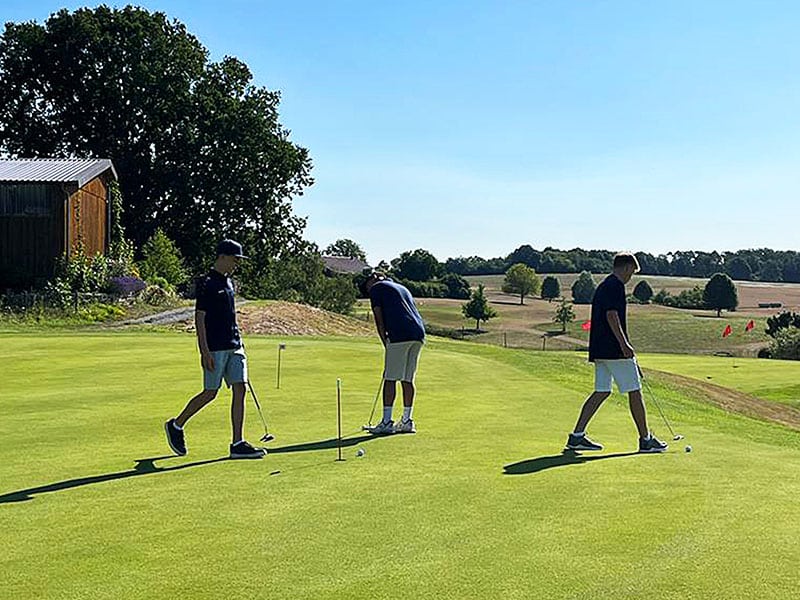 Drei jugendliche Golfspieler auf dem Putting Green des Golfclub Kaiserhöhe